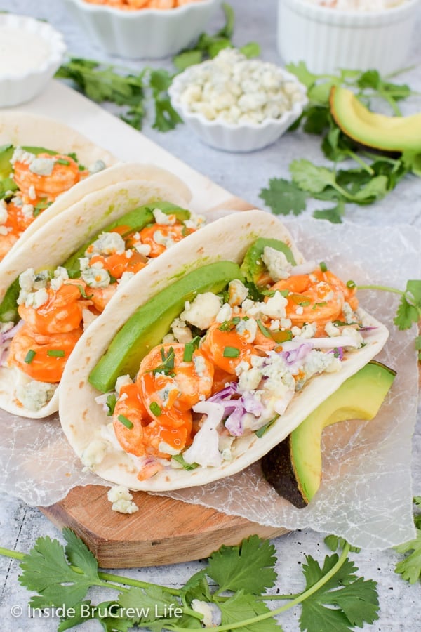 Easy Buffalo Shrimp Tacos - buffalo shrimp, coleslaw, and toppings wrapped in a tortilla makes a quick and easy dinner. Make this easy recipe for busy nights! #tacos #buffaloshrimp #shrimptacos #tacotuesday