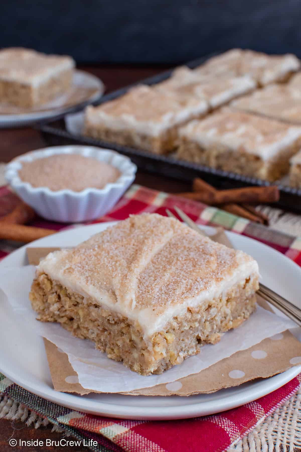 A slice of frosted cinnamon apple bar on a plate.