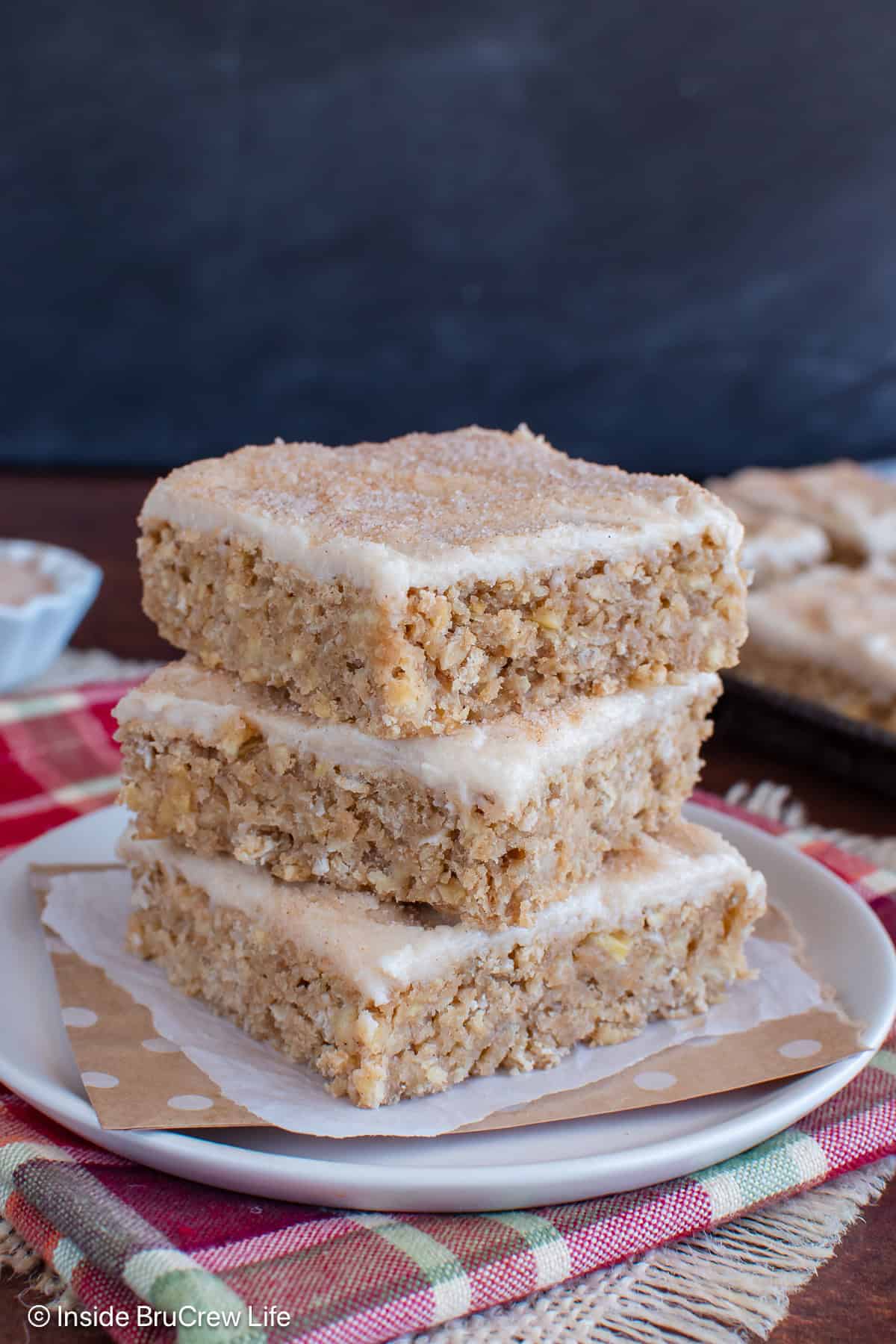 Three cinnamon apple bars stacked on a plate.