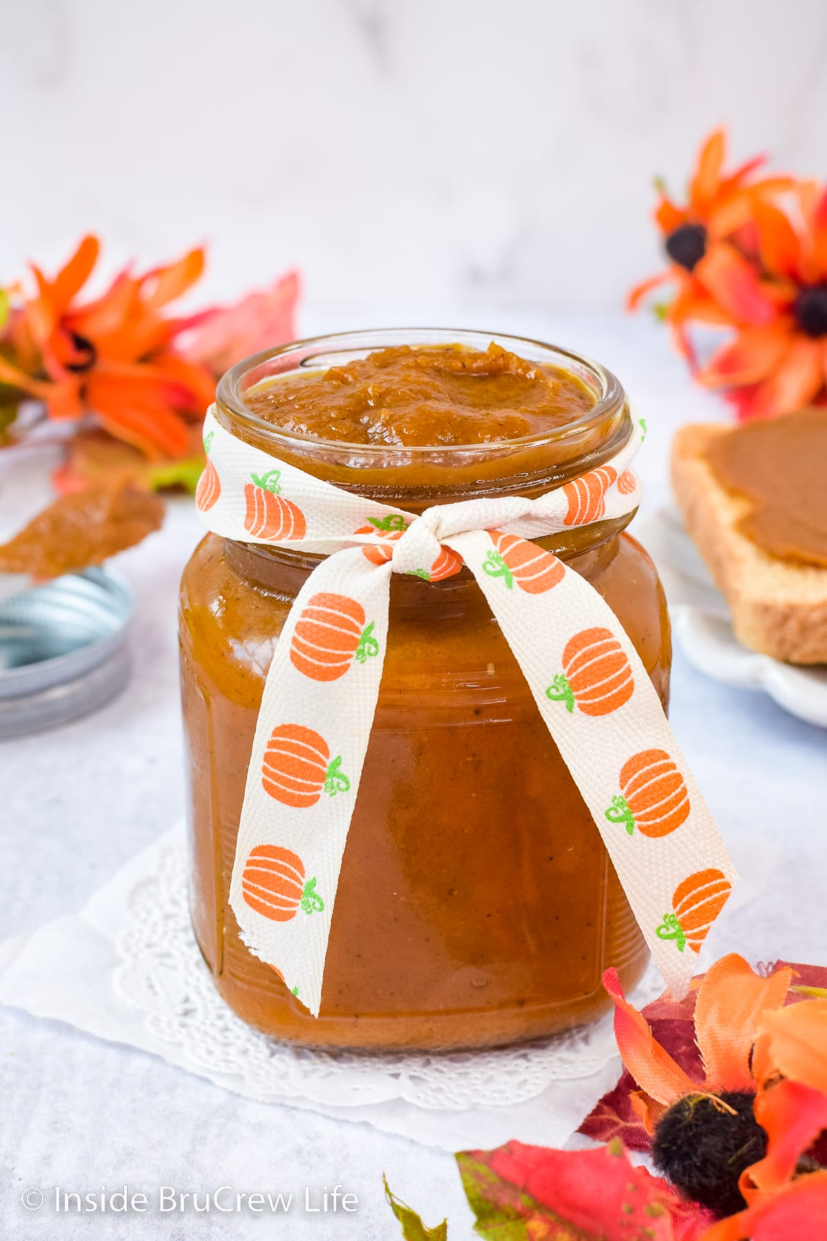 A clear jar filled with pumpkin butter.