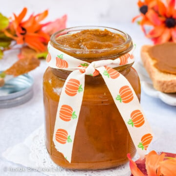 A clear jar with a ribbon filled with pumpkin spread.