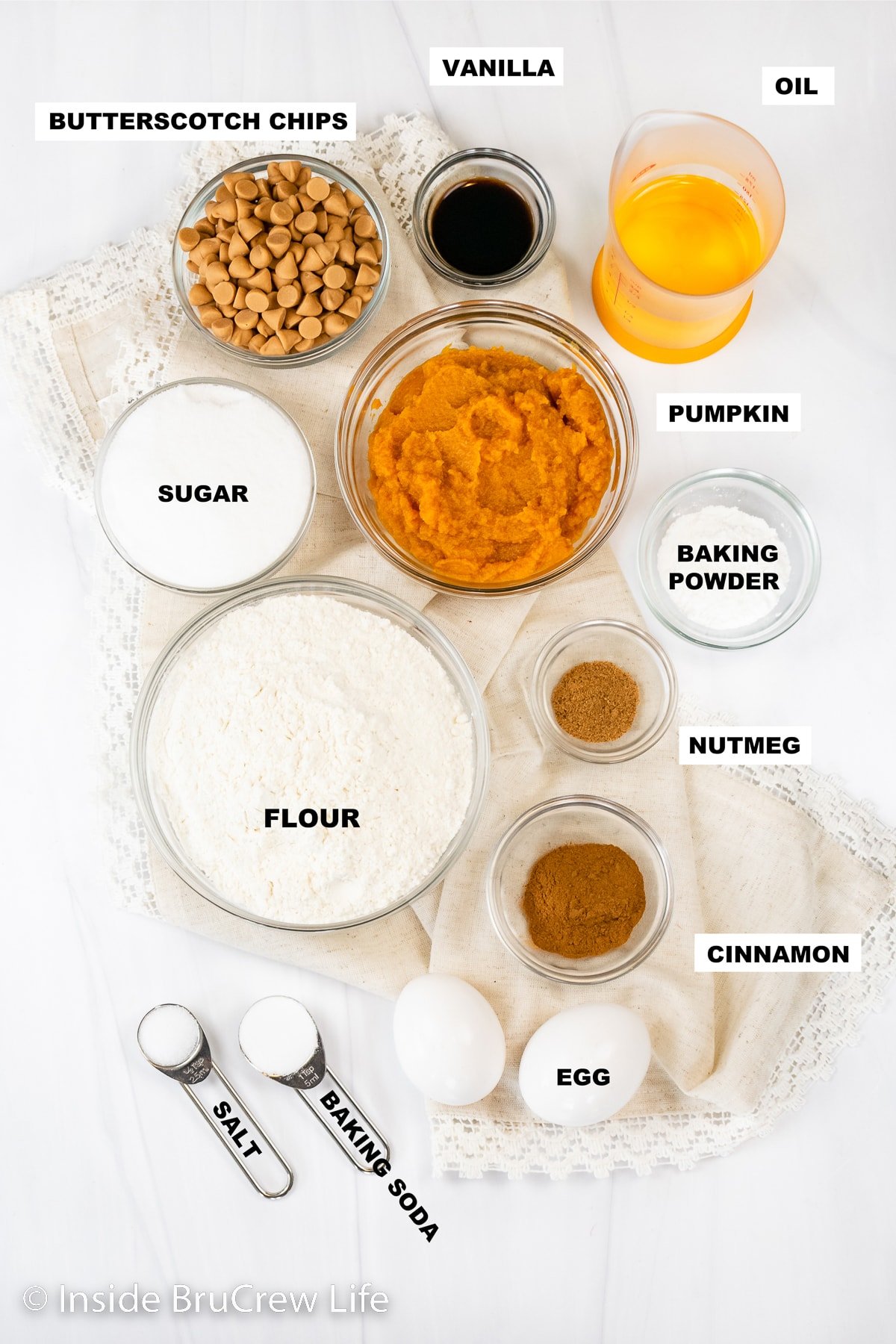 A white board with ingredients to make pumpkin cookies on it.