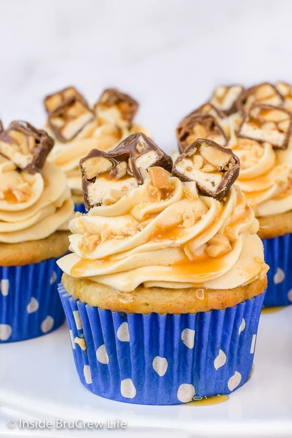 Caramel Apple Cupcakes - these easy apple spice cupcakes are topped with the best caramel frosting and candy bars. Try this easy recipe for fall parties this year! #cupcakes #caramelapple #caramelfrosting #Snickers