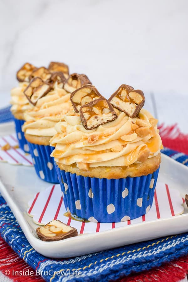 Caramel Apple Cupcakes - these easy apple cupcakes are topped with the best caramel frosting and Snickers candy bars. Make this easy recipe for parties and events this fall. #cupcakes #caramelapple #caramelfrosting #Snickers