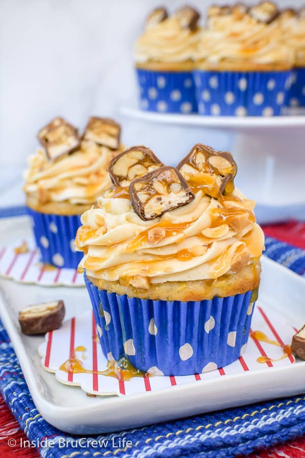 Caramel Apple Cupcakes - homemade caramel buttercream and candy bars add a fun flair to these easy apple cupcakes. Great recipe to make for parties and events this fall. #cupcakes #caramelapple #caramelfrosting #Snickers