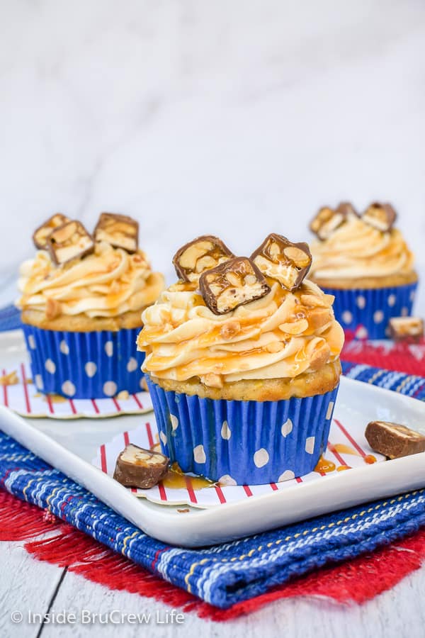Caramel Apple Cupcakes - homemade caramel icing and Snickers candy bars make these easy apple spice cupcakes a delicious fall treat. Make this easy recipe for parties this fall. #cupcakes #caramelapple #caramelfrosting #Snickers