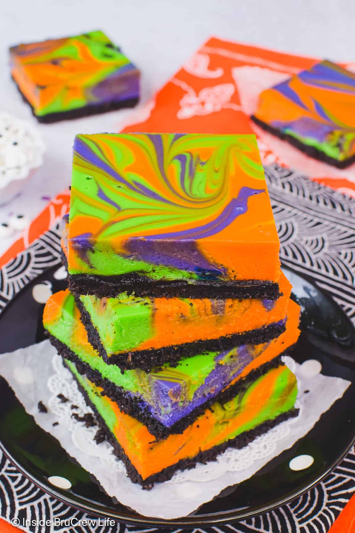 A stack of Halloween swirled cheesecake bars on a plate.