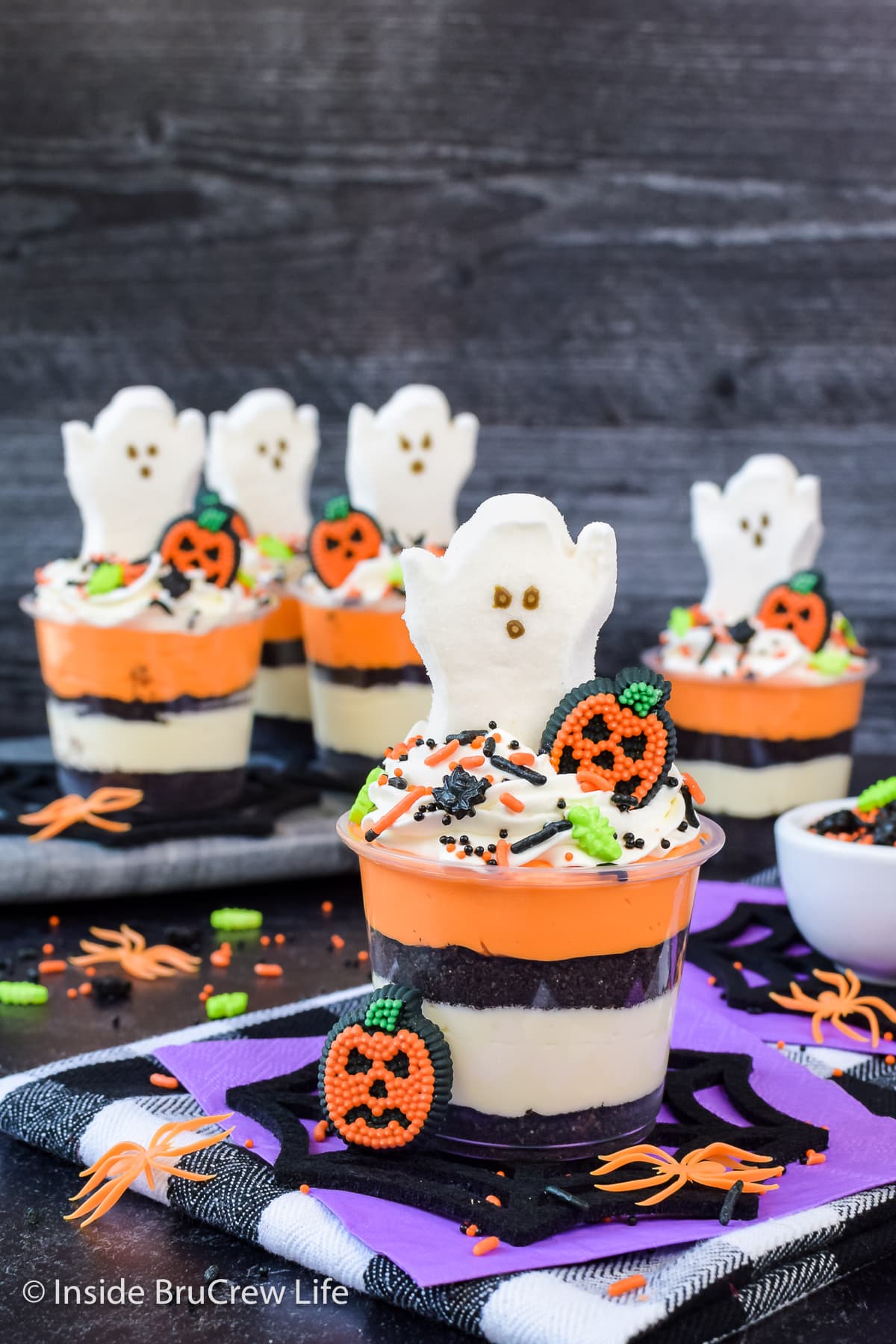 Mini cheesecake parfaits topped with marshmallow ghosts and candies.