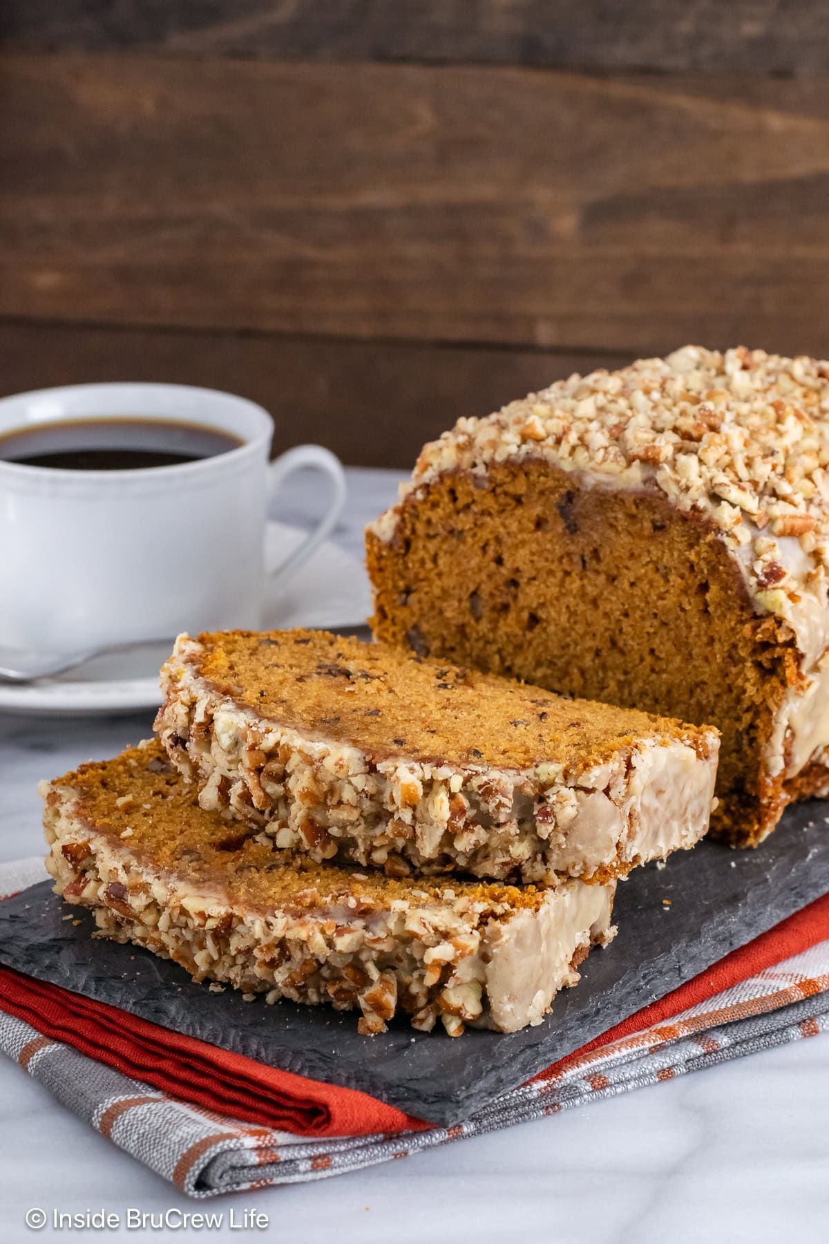 Pumpkin bread with pecans on a slate tray.