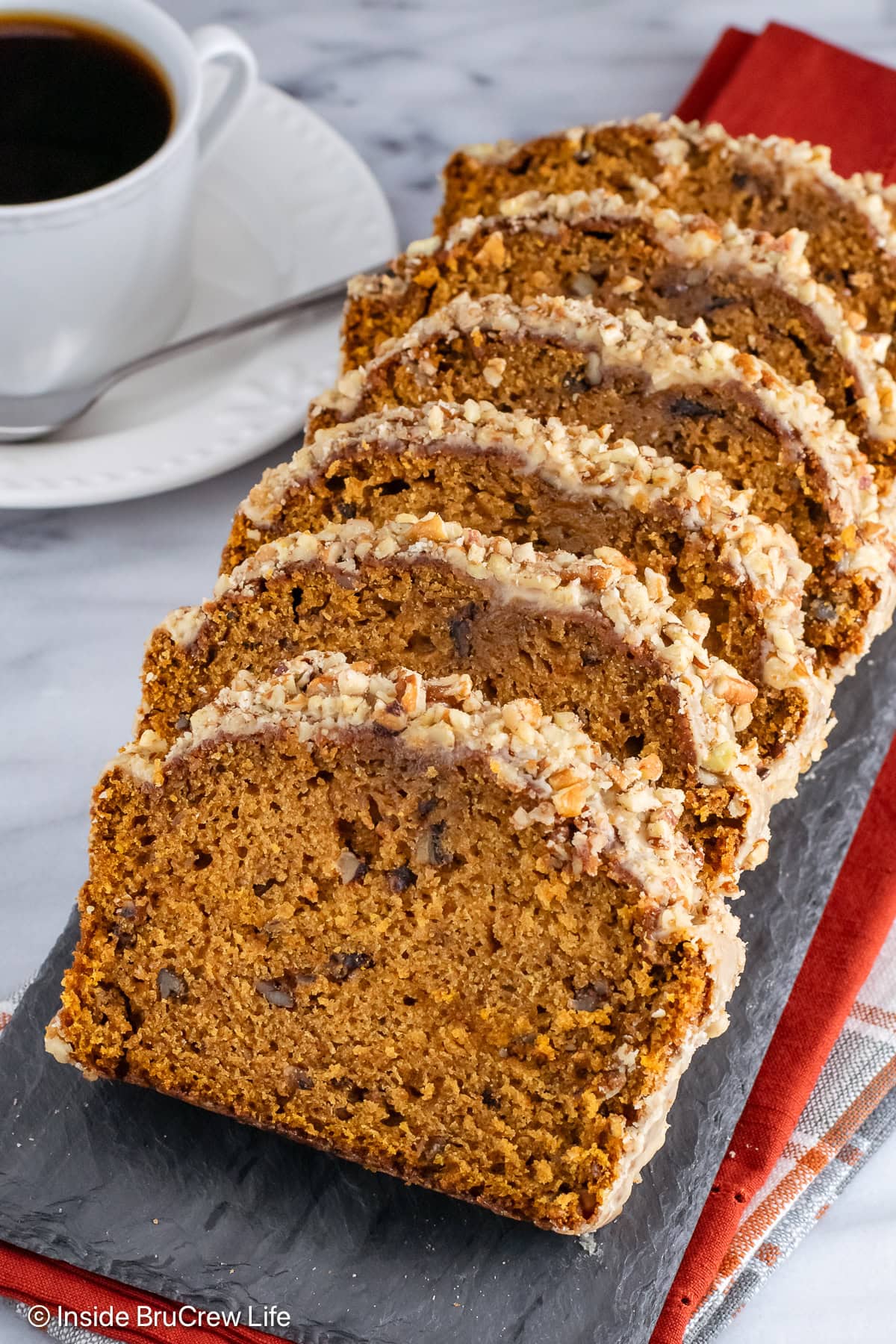 Pumpkin nut bread slices with frosting.