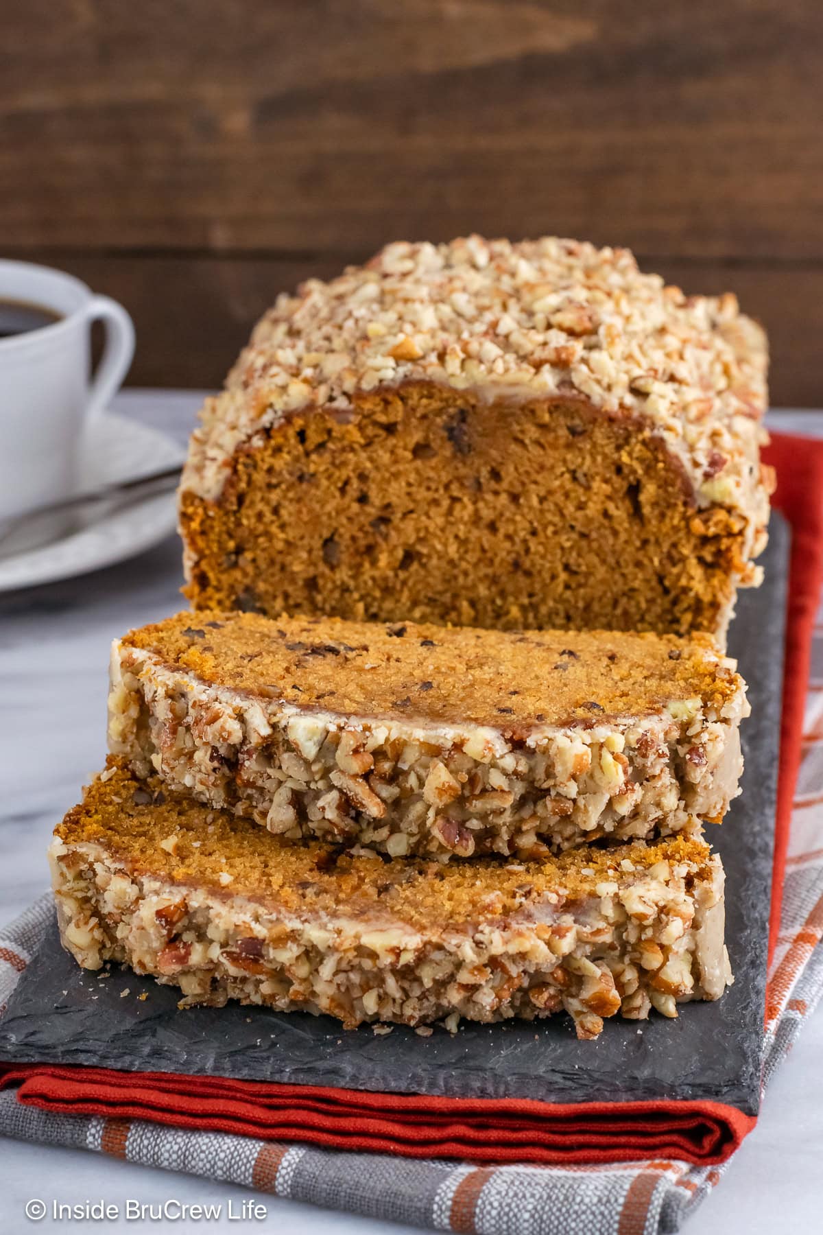 A loaf of pumpkin nut bread on a slate board.