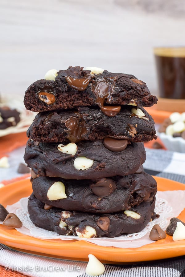 An orange plate with a stack of triple chip pumpkin cookies on it.