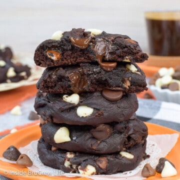 A stack of dark chocolate pumpkin cookies on an orange plate.