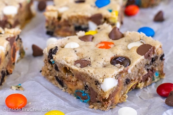 Close up of a blonde brownie square loaded with chocolate, candy, and cookies