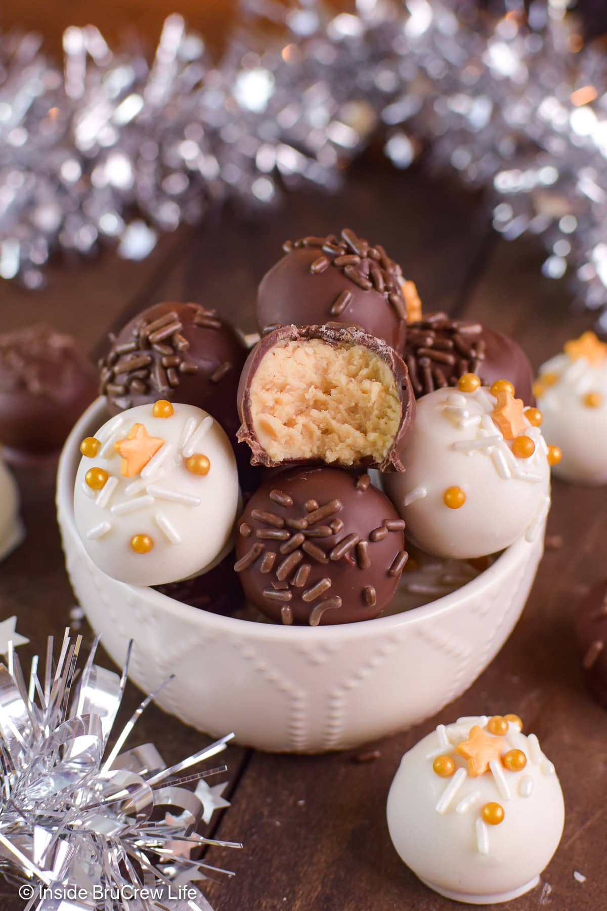 Chocolate covered peanut butter balls in a white bowl.