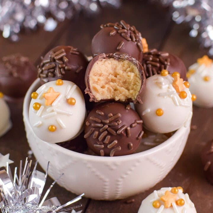 Chocolate covered peanut butter balls in a white bowl.