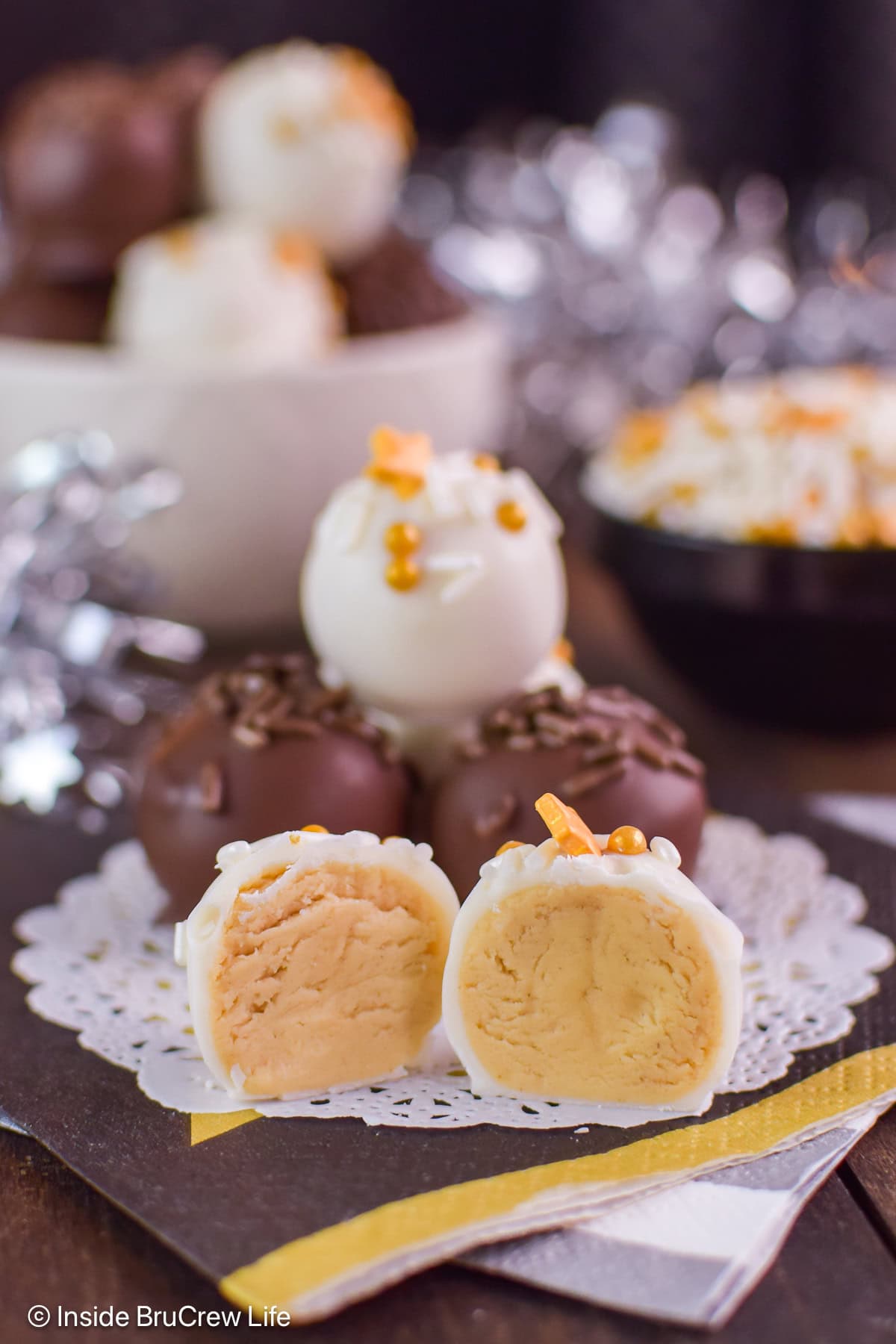 Chocolate covered peanut butter truffles with one cut open.