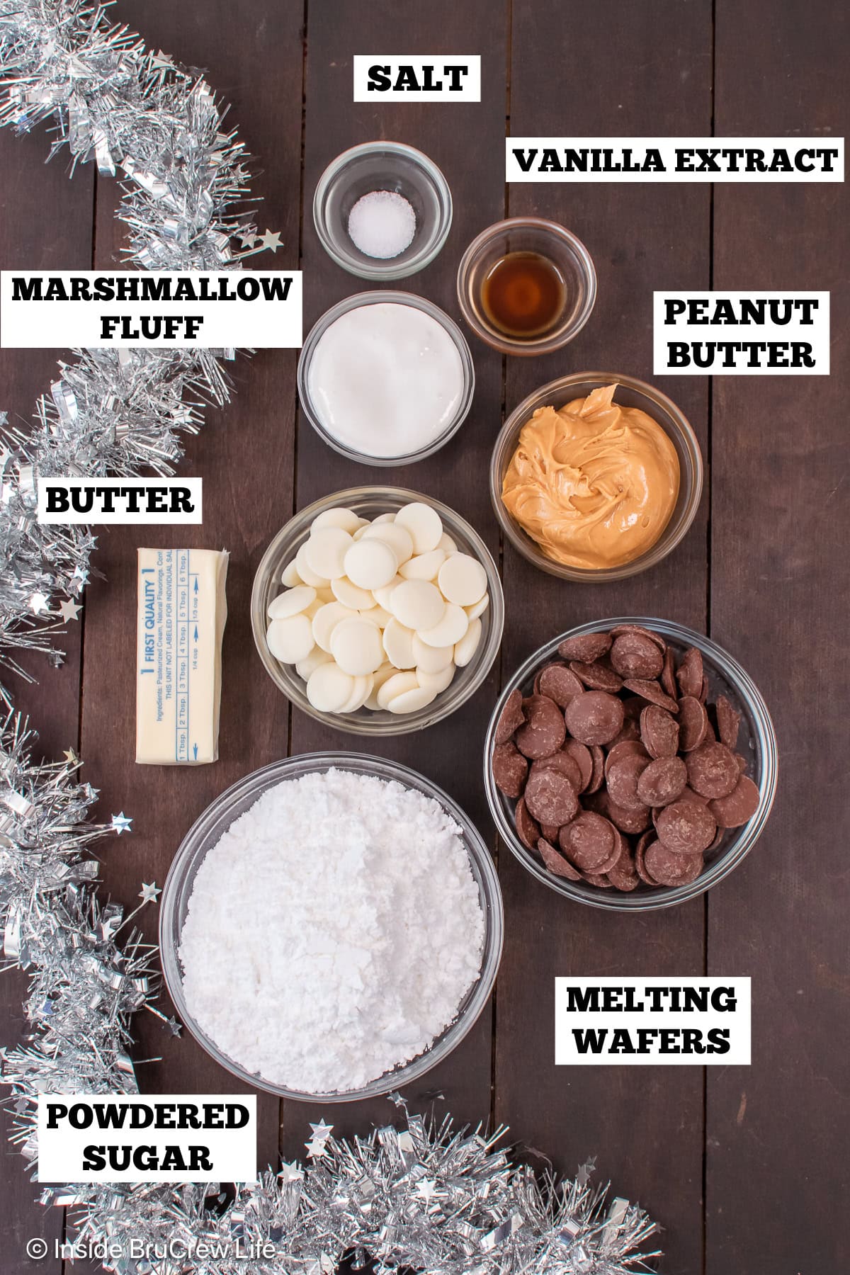 A brown board with bowls of ingredients needed to make peanut butter truffles.