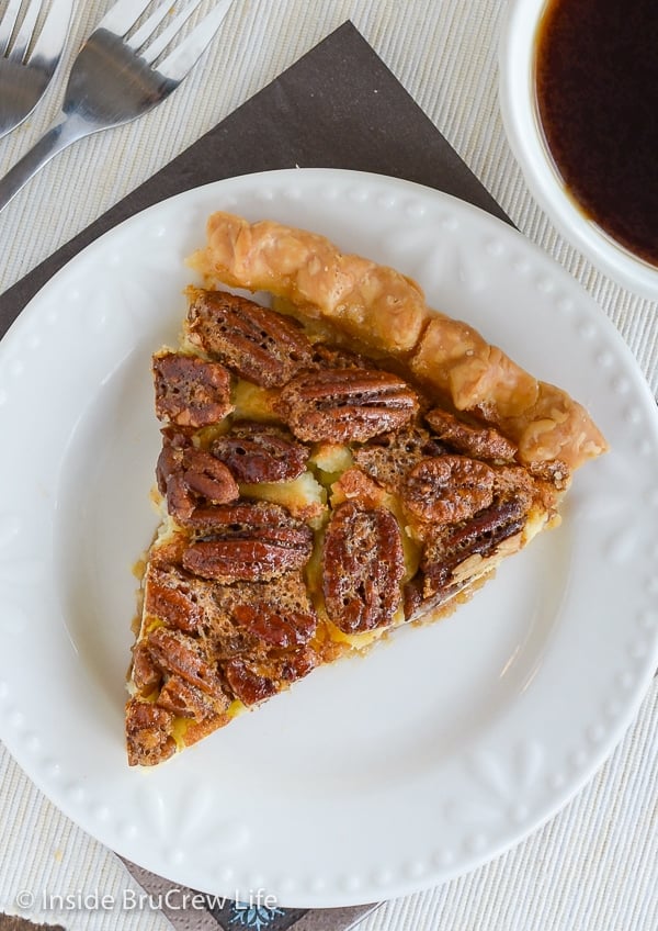 A slice of pecan pie cheesecake on a white plate.