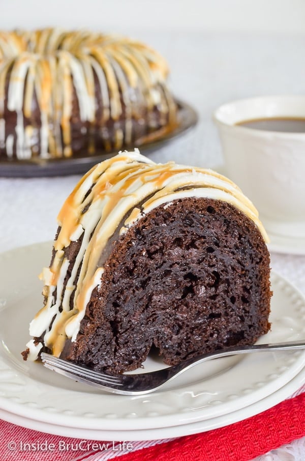 A white plate with a slice of mocha bundt cake topped with white chocolate, caramel, and sea salt.