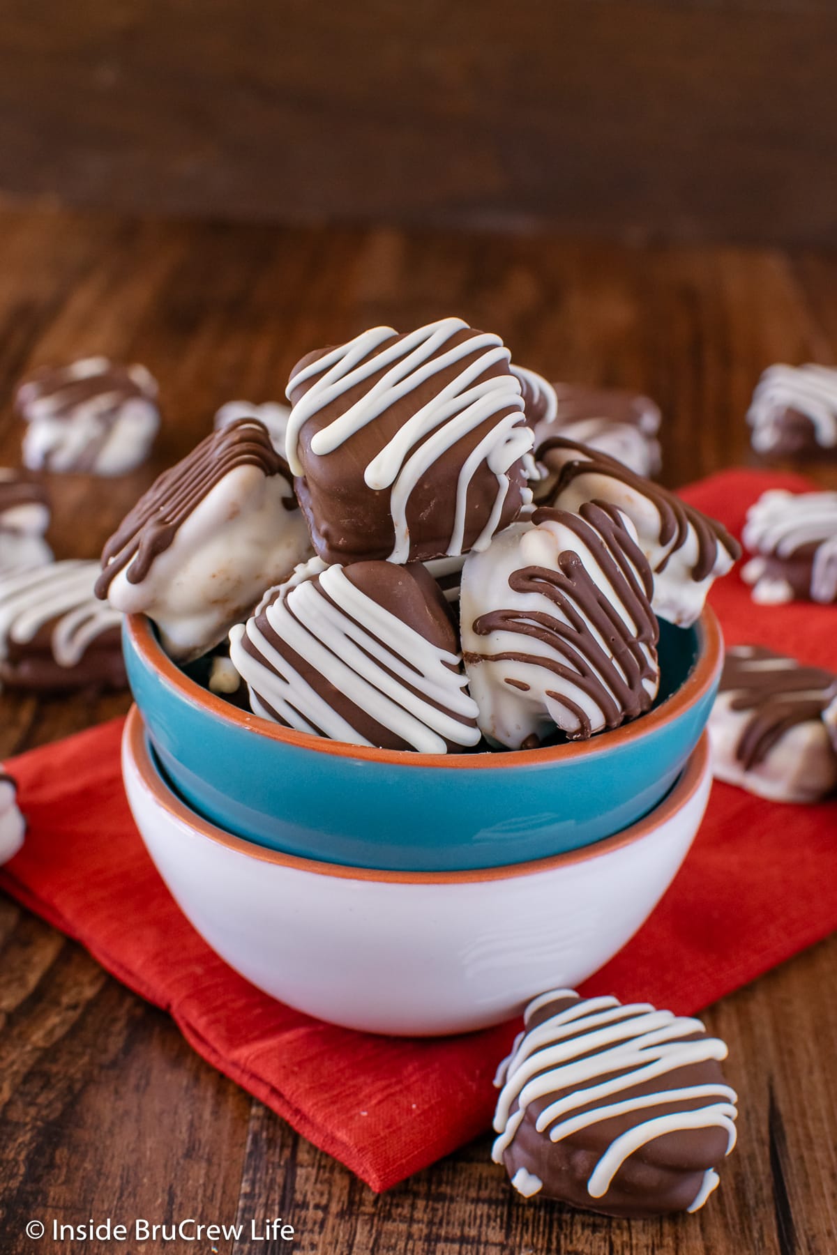 A blue bowl filled with chocolate covered waffle pretzels.