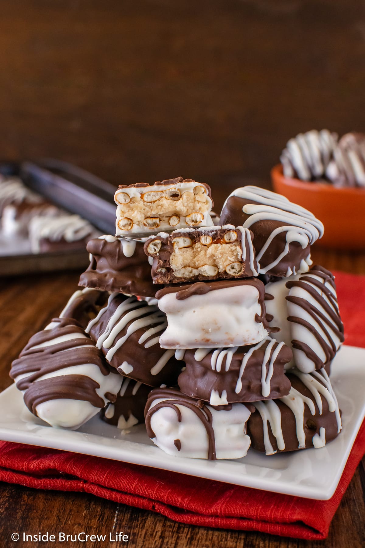 A stack of peanut butter pretzels on a white plate.