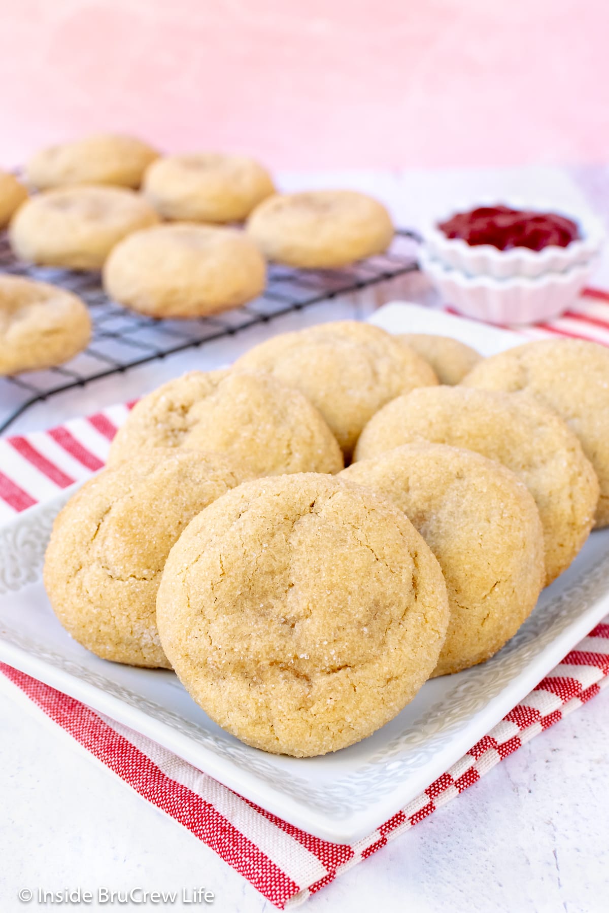 A white plate piled with soft stuffed sugar cookies.