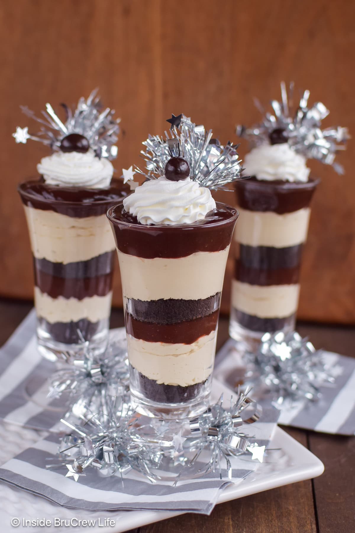 Three cups filled with coffee cheesecake and chocolate pudding.