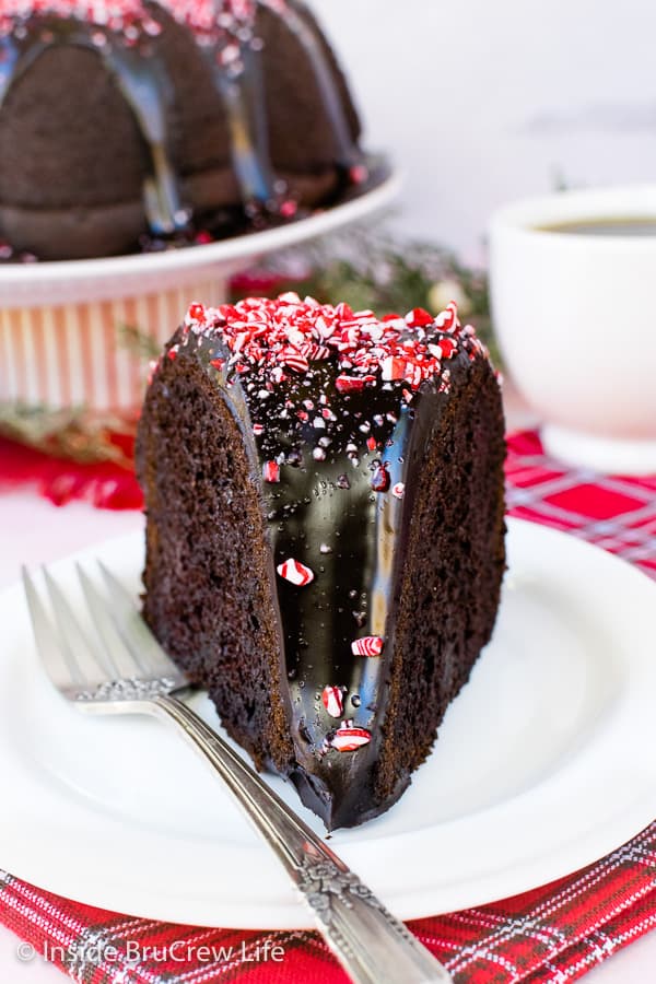 A white plate with a slice of chocolate cake on it.