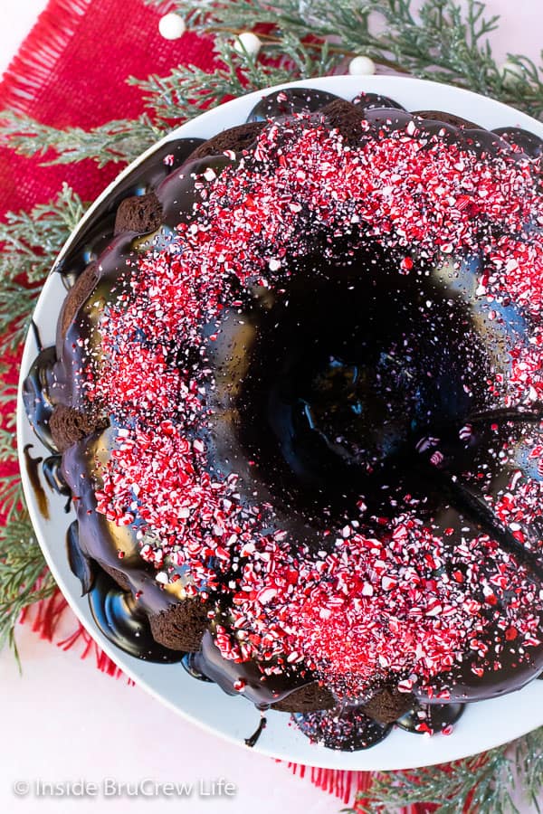 Overhead picture of a chocolate bundt cake topped with ganache and peppermint bits.