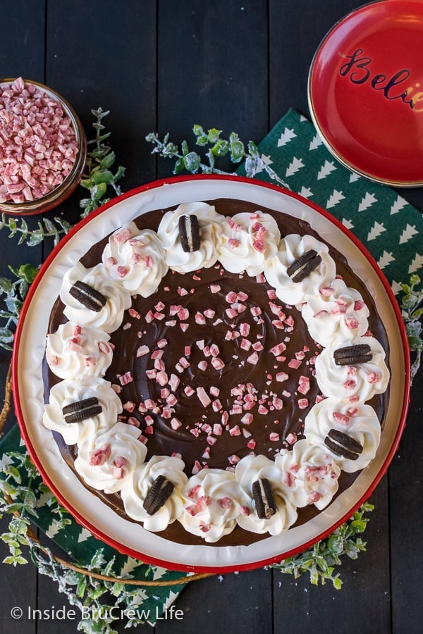 An overhead shot of a Peppermint Oreo Swirl Cheesecake topped with chocolate and whipped cream.