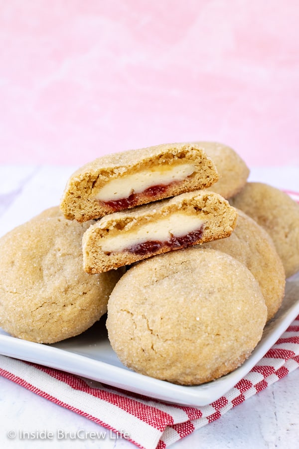 Strawberry Cheesecake Stuffed Cookies - strawberry preserves and cheesecake filling inside of a soft sugar cookies. Make this fun cookie for parties and events. #cookies #cheesecake #stuffedcookies #sugarcookies #strawberry