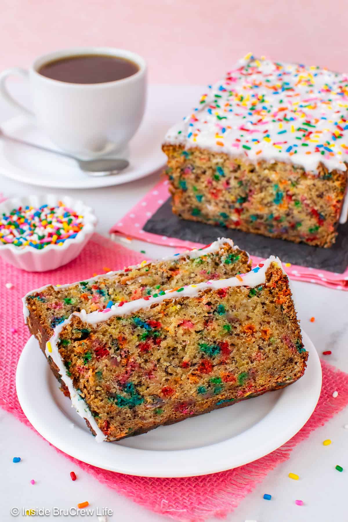 Two slices of Funfetti birthday cake banana bread on a white plate.