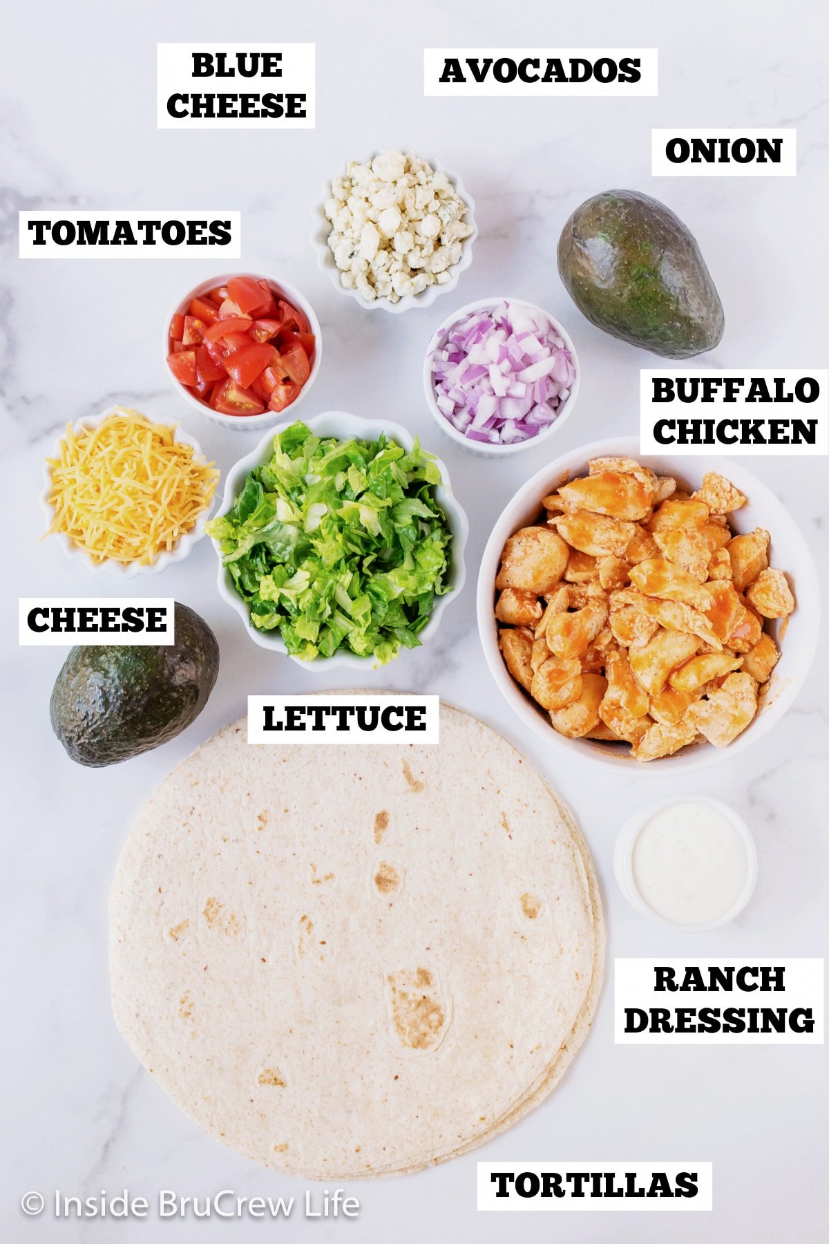 A white board with bowls of ingredients needed to fill tortilla shells.
