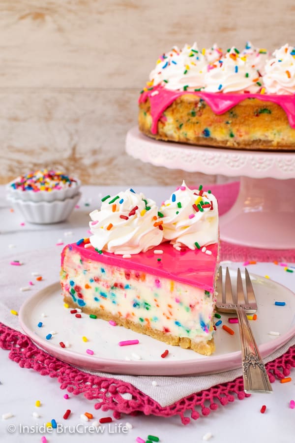 Funfetti Cheesecake - lots of colorful sprinkles and a pink white chocolate glaze makes this cake batter cheesecake look and taste amazing. #cheesecake #funfetti #cakebatter #sprinkles