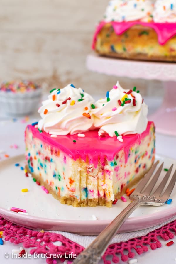 Funfetti Cheesecake - a creamy cake batter cheesecake loaded with colorful sprinkles and topped with a pink white chocolate glaze is perfect for any celebration. #cheesecake #funfetti #cakebatter #sprinkles