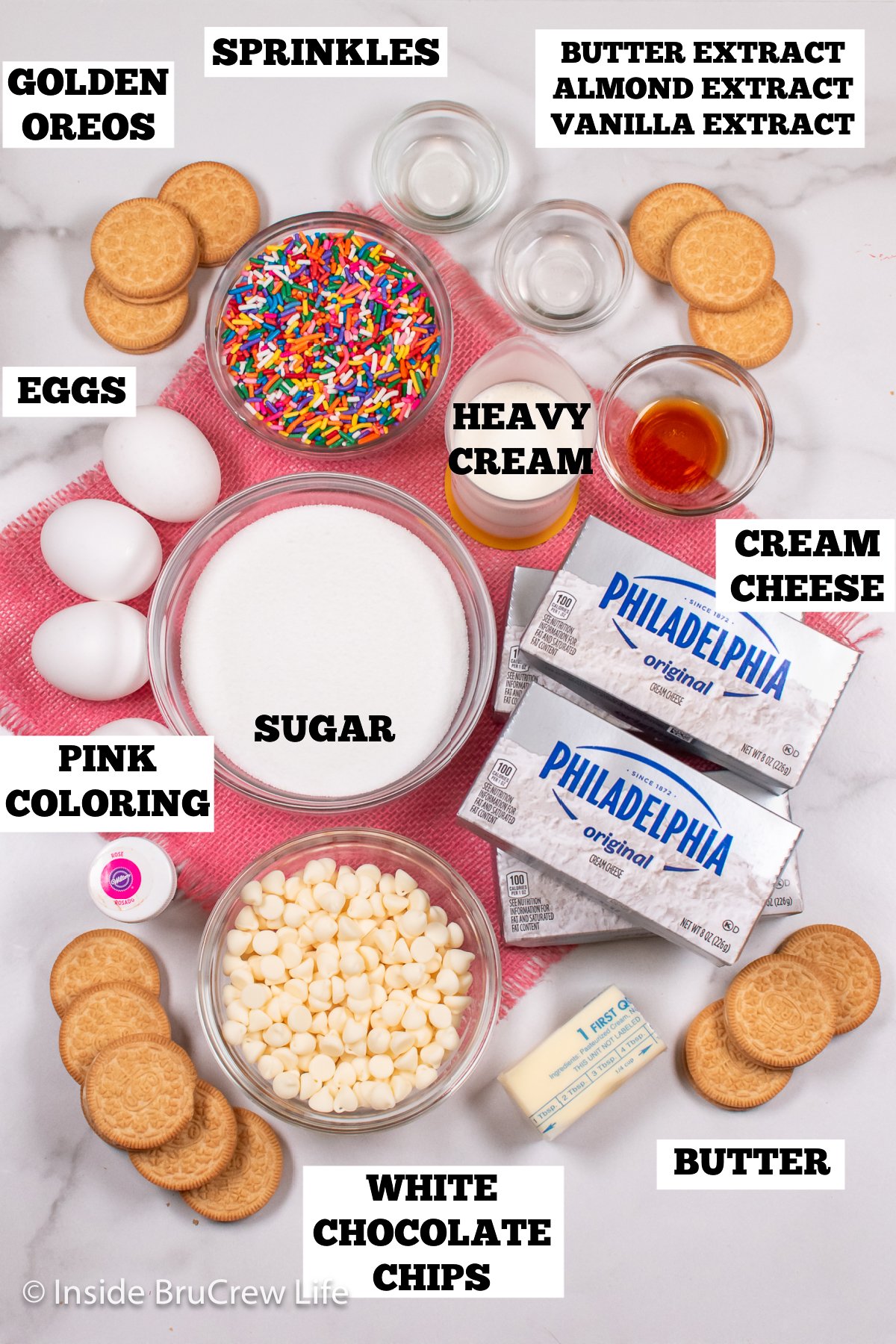 A white board with ingredients needed to make a cheesecake with sprinkles.