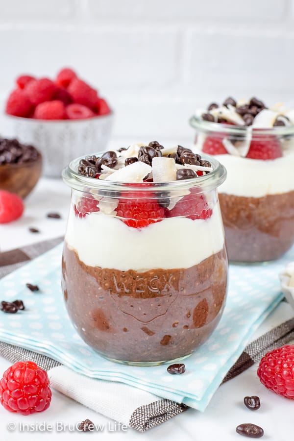 Two clear jars with layers of mocha chia pudding and coconut yogurt in them.