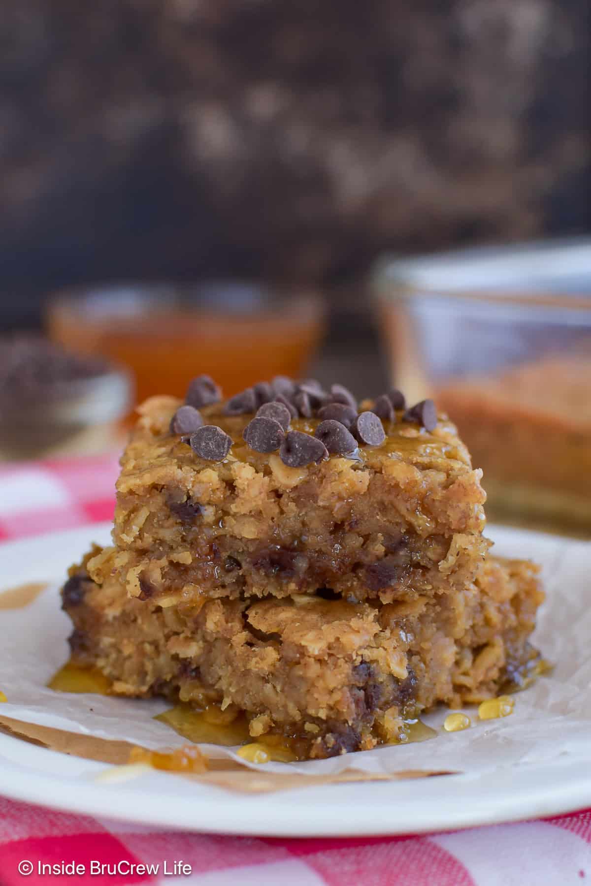 A white plate with two baked peanut butter oatmeal squares on it.