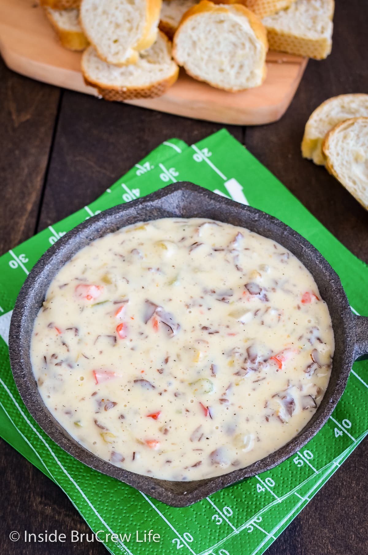 A black skillet filled with cheesy queso dip.