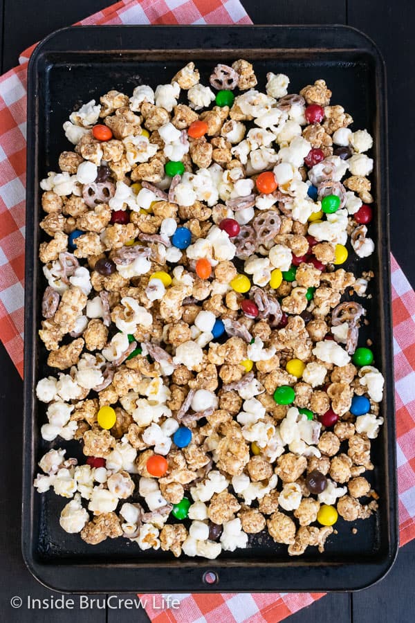 White Chocolate Peanut Butter Pretzel Popcorn - pretzels, peanut butter, and white chocolate give this easy snack mix a fun and delicious coating. Make this no bake recipe for game days or movie nights! #popcorn #chocolatecoveredpopcorn #whitechocolate #peanutbutter #pretzel #gameday #snackmix #nobake