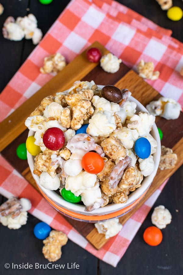 White Chocolate Peanut Butter Pretzel Popcorn - this easy chocolate covered popcorn is loaded with pretzels, marshmallows, and peanut butter candies. Great recipe for game days or movie nights! #popcorn #chocolatecoveredpopcorn #whitechocolate #peanutbutter #pretzel #gameday #snackmix #nobake