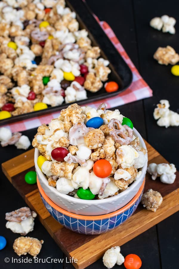 White Chocolate Peanut Butter Pretzel Popcorn - this easy chocolate covered popcorn is loaded with marshmallows, peanut butter candies, and pretzels. Easy recipe to make and snack on during movies or games! #popcorn #chocolatecoveredpopcorn #whitechocolate #peanutbutter #pretzel #gameday #snackmix #nobake