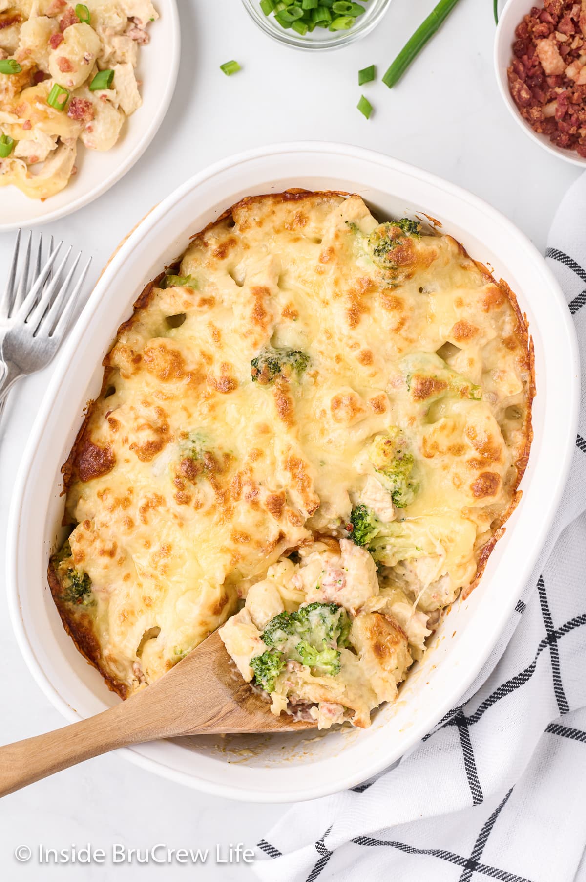 An overhead picture of cheesy pasta in a white casserole dish.