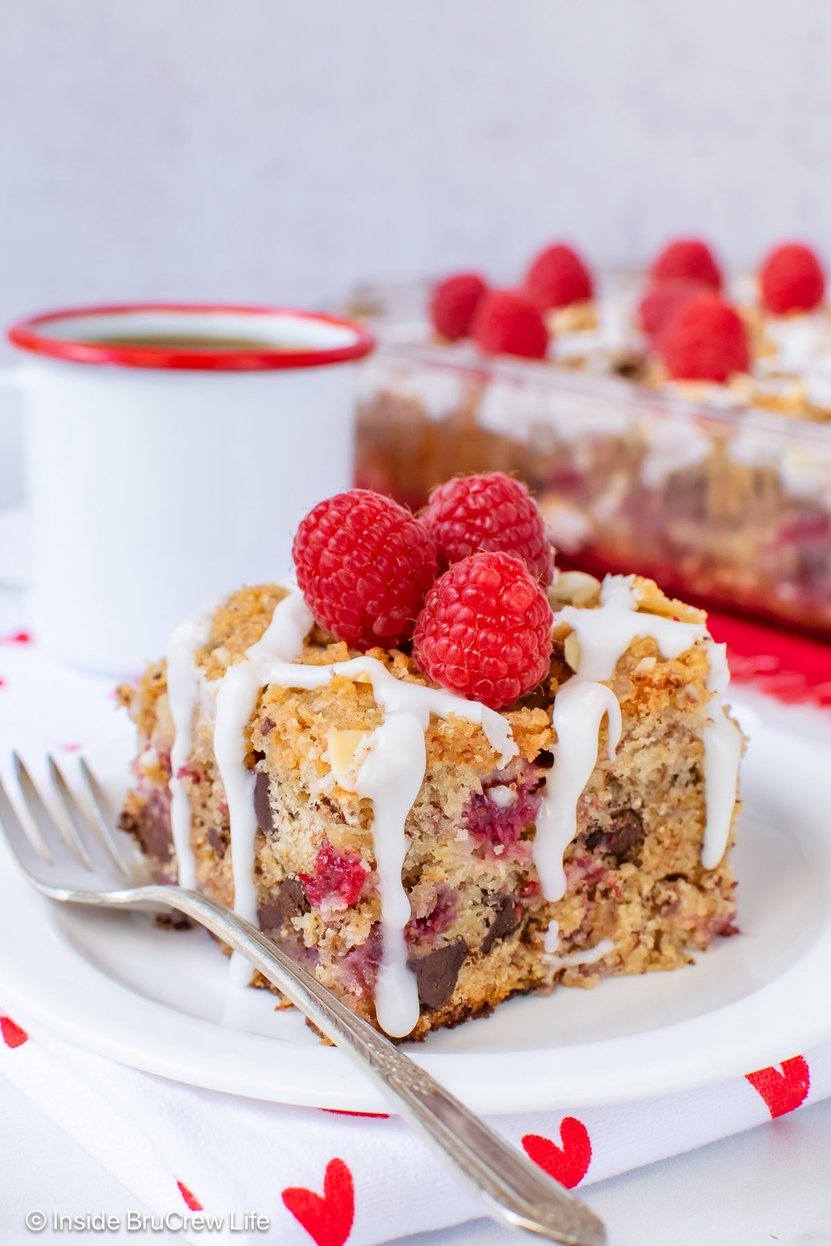 A square of raspberry banana cake on a white plate.