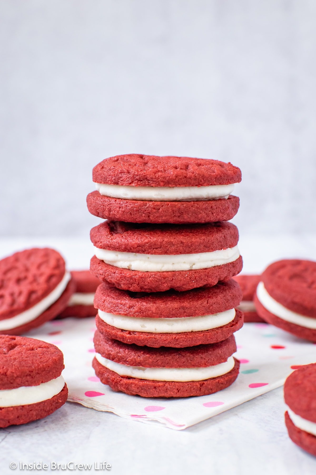 A stack of four red Oreos on a napkin.