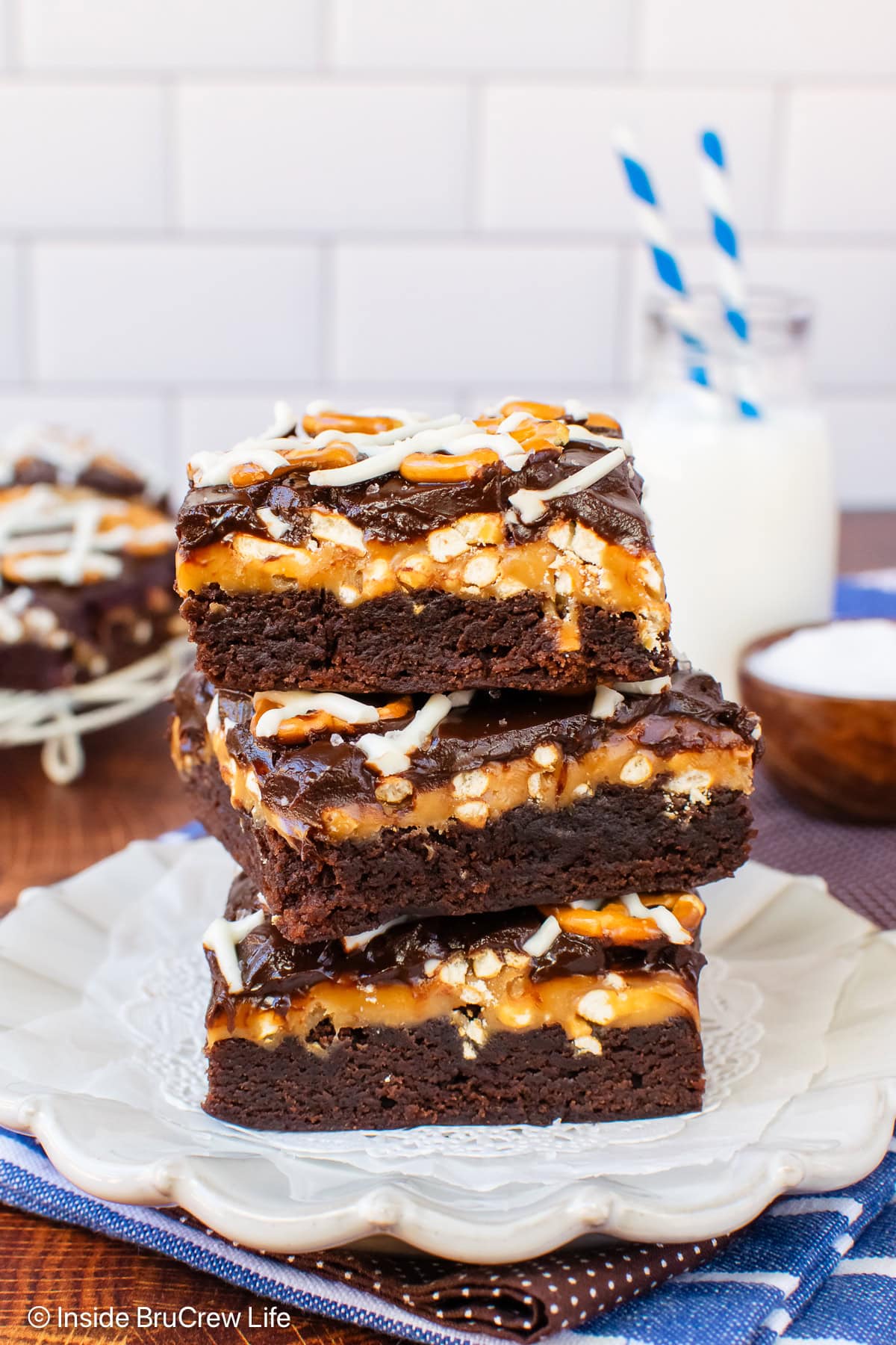 Three salted caramel chocolate brownies stacked on a plate.