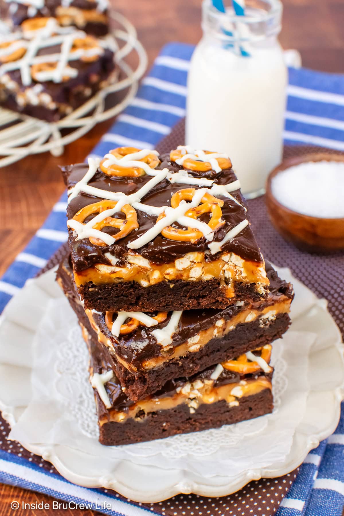 Brownies with pretzels and chocolate on a plate.