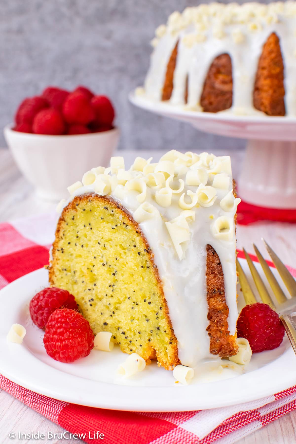 A slice of lemon bundt cake with lemon glaze on a white plate.