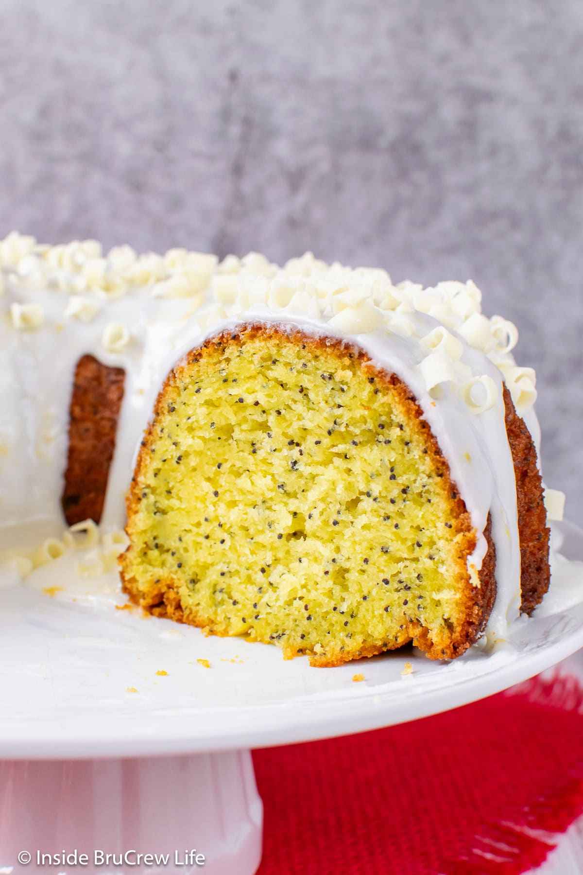 A lemon poppy seed cake on a white plate.